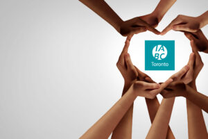 Diverse hands form a heart to represent inclusion with the IABC/Toronto logo in the middle.