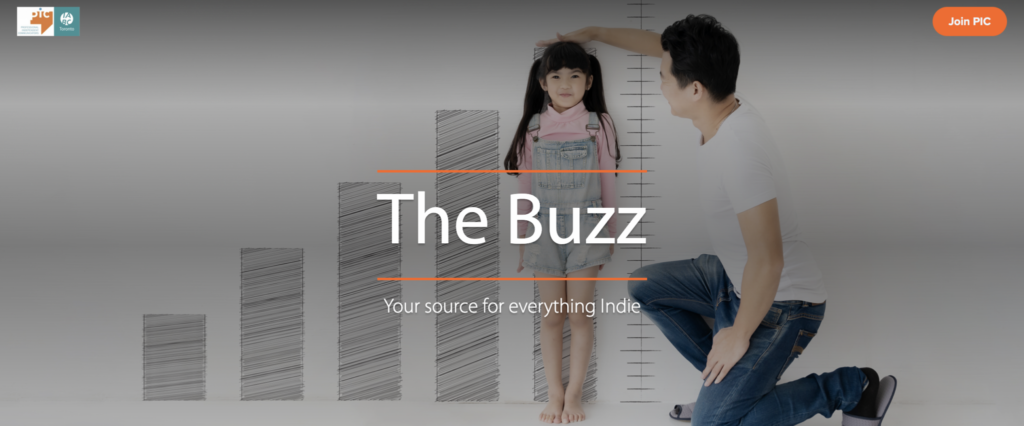 A young girl presses her back to a wall as her father holds a hand on her head to measure her growth. Text reads, “The Buzz. Your source for everything indie.” The I A B C Toronto and PIC logos are on the top left and a “Join PIC” button top right.